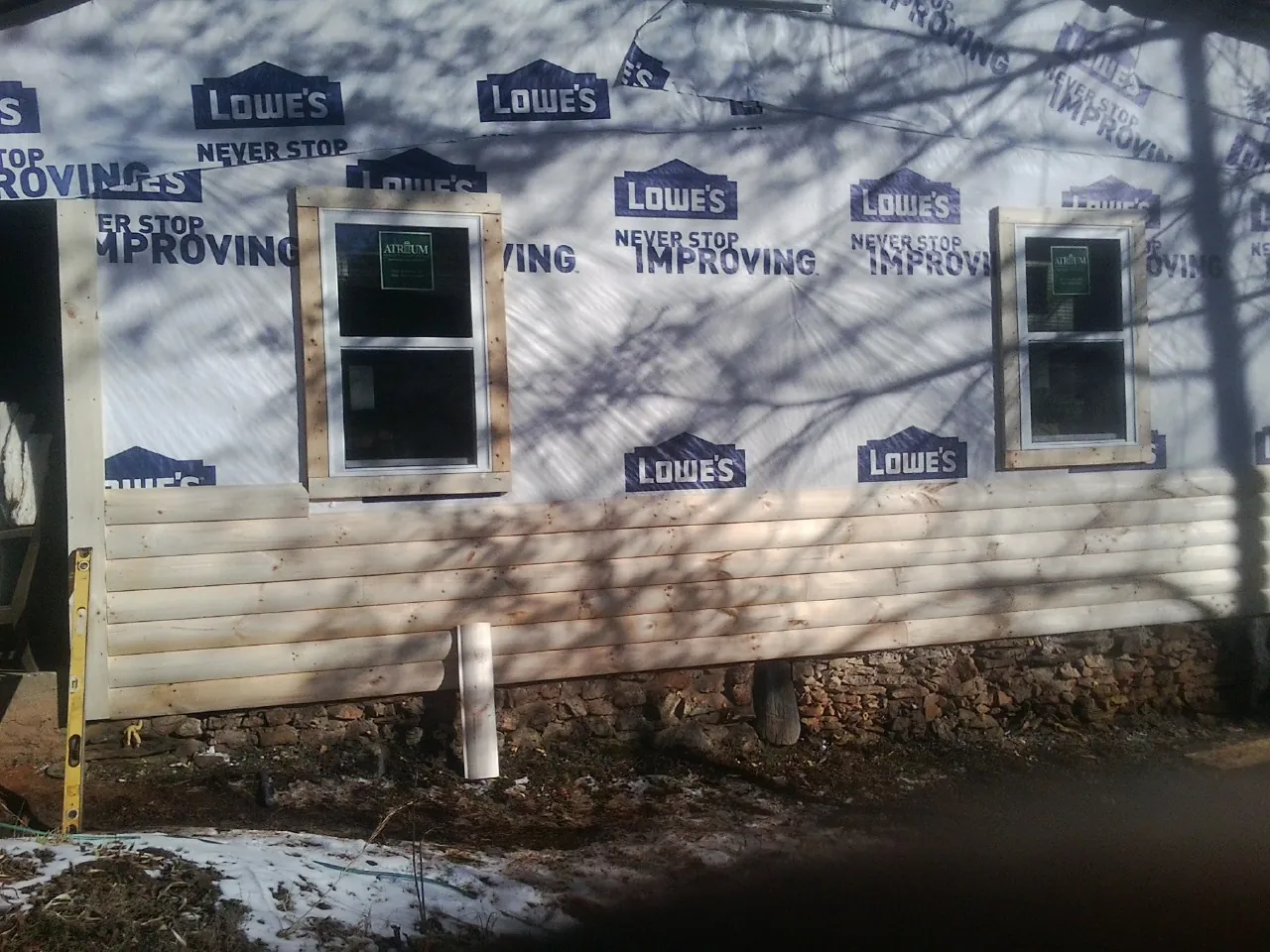 House wrap and new log siding going up on an exterior wall in Vidalia