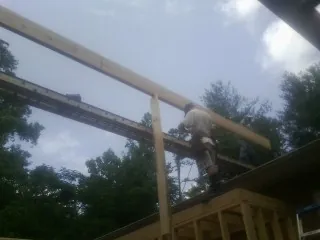 Carpenter setting a ridge beam over a new addition frame — Ice Dam Removal by Roofing Brothers in Vidalia