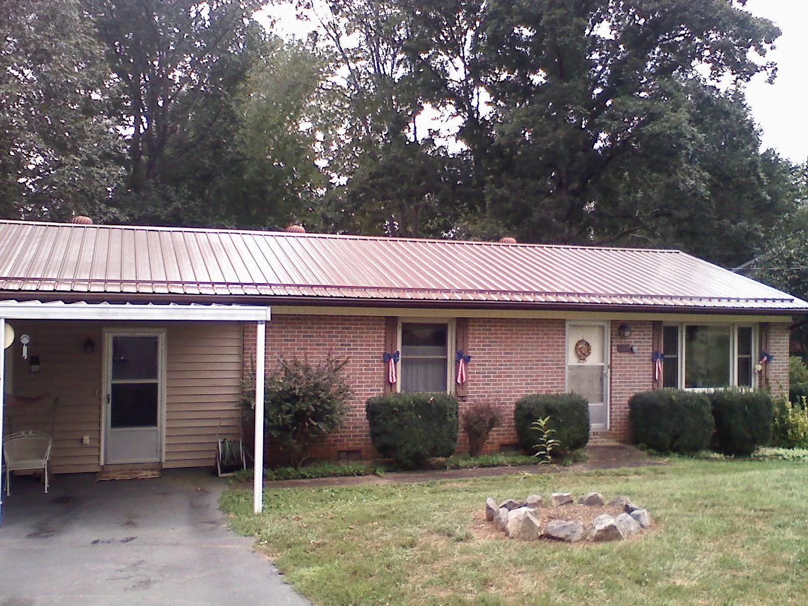 Bronze metal roof and carport on a brick ranch home — Roof Repair work by our crew in Vidalia